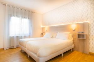 Łóżko lub łóżka w pokoju w obiekcie Hostal Gran Duque