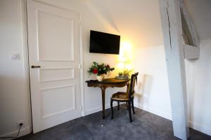 Una habitación con una puerta y una mesa con flores. en L’Atelier, en Saint-Denis-sur-Loire