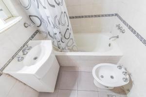 baño blanco con bañera, lavabo y aseo en Apart amplio Palermo chico en Buenos Aires