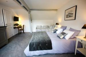 a bedroom with a large white bed and a desk at L’Atelier in Saint-Denis-sur-Loire