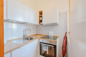 a small kitchen with a sink and a stove at Elisa Apartment by Rentbeat in Ostuni