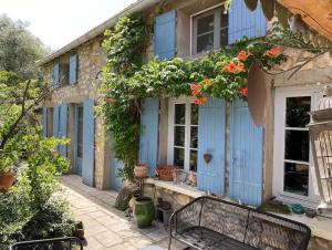 una casa azul con un banco delante en Cottage chaleureux avec piscine privée, en Sainte Anastasie - Aubarne
