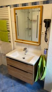 a bathroom with a sink and a mirror and green towels at Anne am Kurpark in Bad Tölz