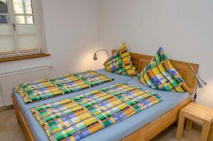 a bed with colorful sheets and pillows in a room at Urlaub beim Winzer, Ferienwohnung 1 in Neustadt an der Weinstraße
