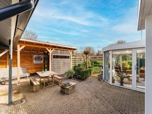 een patio met een bank en een paviljoen bij Amazing holiday home in Lauwersoog with sauna in Lauwersoog
