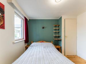 een slaapkamer met een bed in een kamer met een raam bij Amazing holiday home in Lauwersoog with sauna in Lauwersoog