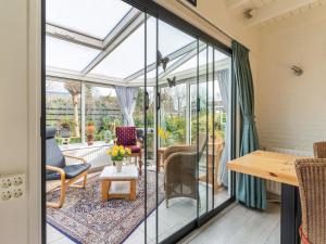 een serre met glazen deuren en een tafel en stoelen bij Amazing holiday home in Lauwersoog with sauna in Lauwersoog