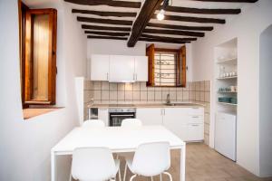 una cucina con tavolo bianco e sedie bianche di A Casa di Peter Pan a Capoliveri