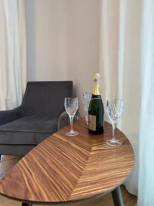 una bottiglia di champagne e due bicchieri di vino su un tavolo di legno di Leśna Residence & SPA a Pisz