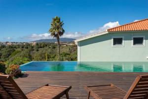 a swimming pool with two chairs and a house at Wonderful Villa near Lisbon in São Domingos de Rana