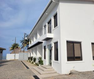 a white house with stairs in front of it at Tramonto Boutique Hotel in La Ceiba
