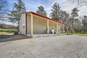 a metal building with a garage on a gravel road at Eureka Springs Area Home with Porch, Grill! in Berryville