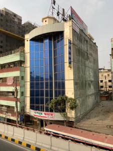 達卡的住宿－Hotel Shahin Residential Jatrabari，街道边的建筑,有蓝色的窗户