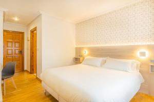 Łóżko lub łóżka w pokoju w obiekcie Hostal Gran Duque