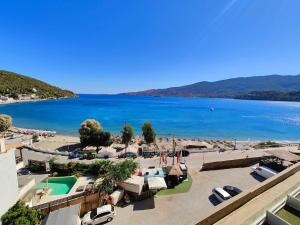 einen Blick auf den Strand und eine Wasserfläche in der Unterkunft New Aegli Resort Hotel in Poros