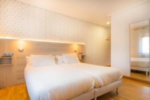 Łóżko lub łóżka w pokoju w obiekcie Hostal Gran Duque