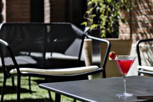 une boisson sur une table avec une fraise dessus dans l'établissement Logis Hôtel Villa du Taur, à Toulouse