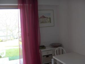 ヴィレンヌ・シュル・セーヌにあるIlvilのピンクのカーテンとテーブル、窓が備わる客室です。