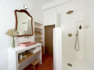 uma casa de banho com um lavatório e um espelho em Maison Caryatides em Cotignac