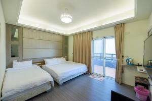 馬公市的住宿－澎湖品澄民宿，酒店客房设有两张床和一个阳台。