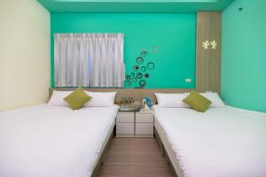 馬公市的住宿－澎湖品澄民宿，绿墙客房内的两张床