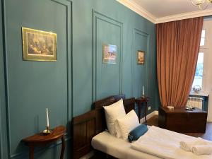 een slaapkamer met een bed en een blauwe muur bij Apartament Baron ***** in Jelenia Góra