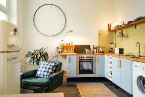 uma sala de estar com uma cadeira e uma cozinha em Ferienwohnung Feel Good Apartment - zentrale 65qm Design Fewo im Zittauer Gebirge - bahnhofsnah in ruhiger Lage em Zittau