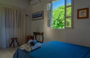 a bedroom with a blue bed and a window at Casa Boomerang in Marau