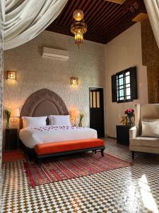 a bedroom with a large bed and a chair at Palais De Fès Suites & Spa in Fès