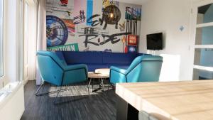 a living room with a blue couch and a table at Walibi Village in Biddinghuizen