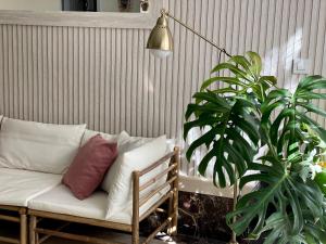um sofá com almofadas, um candeeiro e uma planta em Hotel Playa del Carmen em Barbate