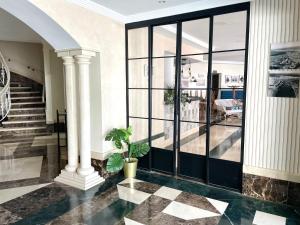 Hotel Playa del Carmen في بارباتي: لوبي وباب زجاجي كبير ونصب خزاف