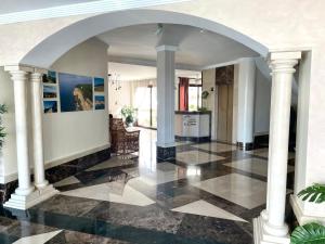 a hallway with columns and a black and white tile floor at Hotel Playa del Carmen in Barbate