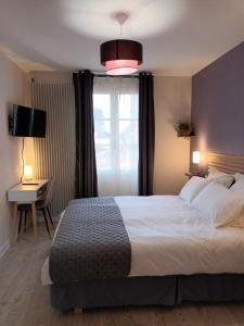 a bedroom with a large bed and a window at Les chambres de la Vallée in Argenton-Château