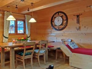a dining room with a table and a clock on the wall at Ferienwohnungen Anni im Paradies in Kiefersfelden