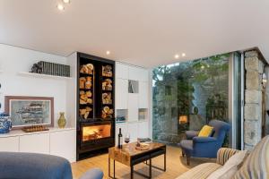 sala de estar con chimenea y sillas azules en Sé Apartamentos - Casa da Rabeta en Forjãis