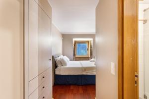 a small bedroom with a bed and a mirror at Sé Apartamentos - Casa da Rabeta in Forjãis