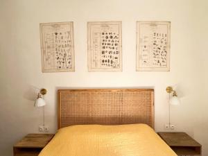 um quarto com uma cama com dois candeeiros e cartazes na parede em Maison Caryatides em Cotignac