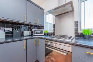 a kitchen with gray cabinets and a stove top oven at Premium 4 Bed Detached in Heswall in Heswall