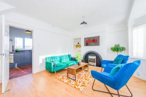 a living room with blue chairs and a fireplace at Premium 4 Bed Detached in Heswall in Heswall