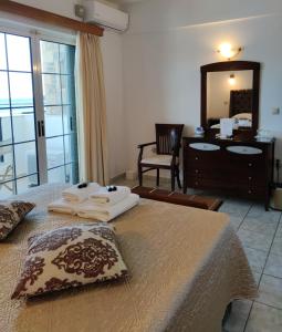 a bedroom with a bed and a dresser and a mirror at Filoxenia Hotel in Monemvasia