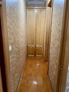 een hal met een houten deur en een vloer bij Apartment in Kutaisi Agmashenebeli in Koetaisi