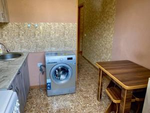 een wasruimte met een wasmachine en een tafel bij Apartment in Kutaisi Agmashenebeli in Koetaisi