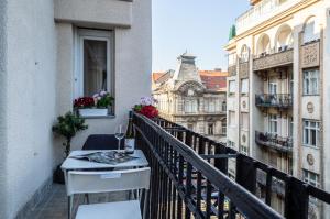 einen Balkon mit einem Tisch und Blick auf ein Gebäude in der Unterkunft Luxury Downtown Home by Anna in Budapest
