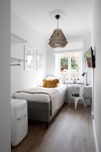 um quarto branco com uma cama e uma janela em WOW, Föreningsgatan 9 em Gotemburgo