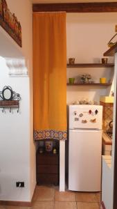 巴勒摩的住宿－Home Casa Professa 1，厨房配有白色冰箱和橙色窗帘