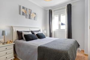 a white bedroom with a large bed and a window at Apartamento Goya in Conil de la Frontera