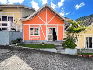 una casa de color naranja y amarillo en Chamego em Teresópolis próximo a feirinha, en Teresópolis