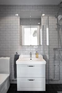a white bathroom with a sink and a shower at WOW, Föreningsgatan 9 in Gothenburg