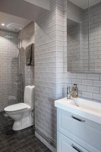 La salle de bains est pourvue de toilettes blanches et d'un lavabo. dans l'établissement WOW, Föreningsgatan 9, à Göteborg